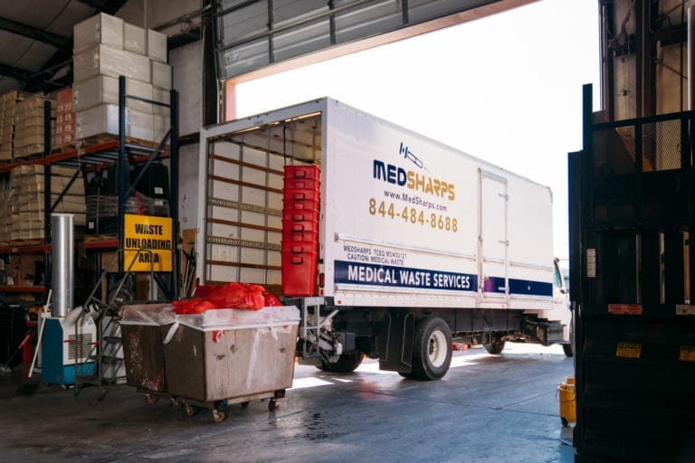 Med Sharp truck unloading tubs of used vaccination needles