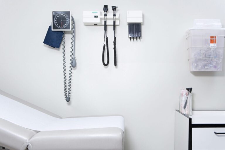 Empty doctor's office with medical equipment and exam table.